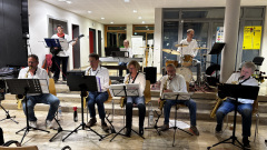 Jazzensemble mit Bläsern, E-Bass, Keyboard und Schlagzeug bei einem Auftritt im Rathausfoyer.