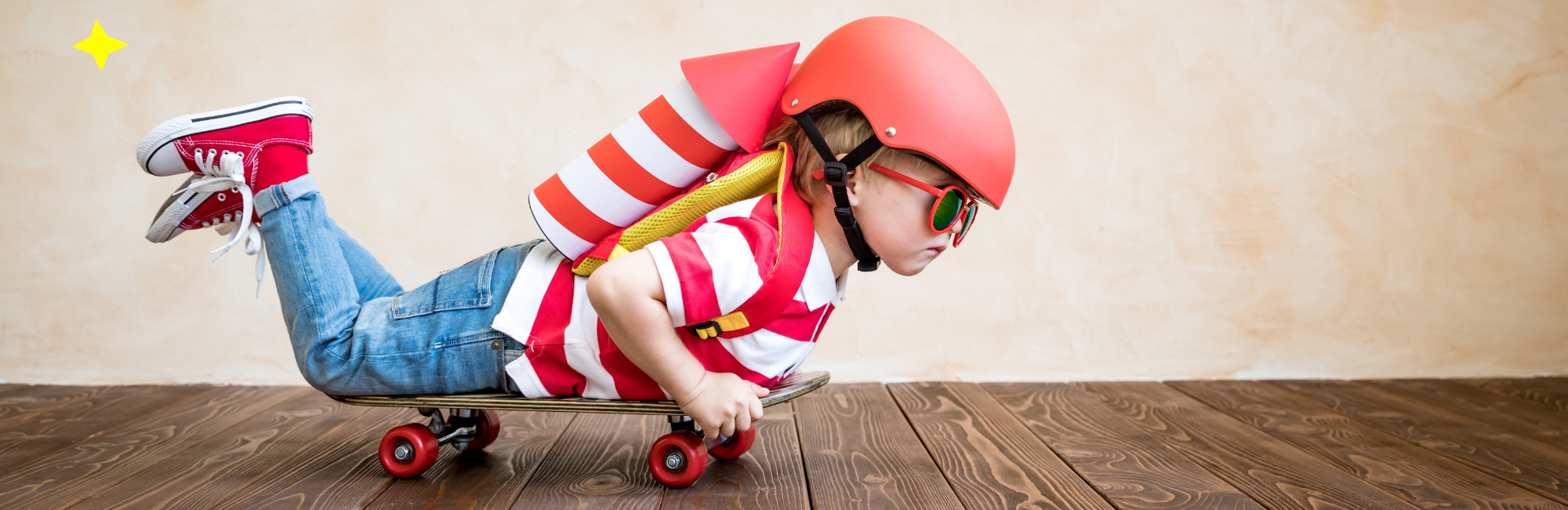 Ein Kind trägt einen roten Helm, Sonnenbrille und einen Rucksack in Raketenform, liegt auf einem Skateboard und schaut entschlossen nach vorne. Gezeichnete Wolken, Sterne und eine Rakete im Hintergrund betonen eine Fantasieszene.