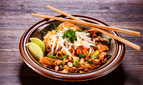Asiatische Nudeln mit Huhn, Limette und Gemüse – traditionelles Streetfood wie Pad Thai