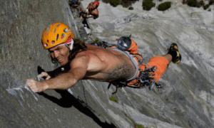 Thomas Huber klettert konzentriert eine steile Felswand hinauf – Symbol für Mut und Leidenschaft im Bergsport