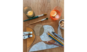 Malutensilien und begonnenes Kunstbild auf einem Tisch.